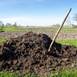 fertilizer: pile of compost near vegetable garden